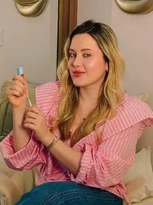 A Dra. Maria Fernanda na poltrona do consultório, de camisa rosa